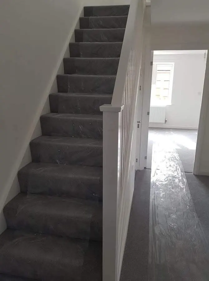 Carpeted staircase and hallway floor covered with protective film before a move